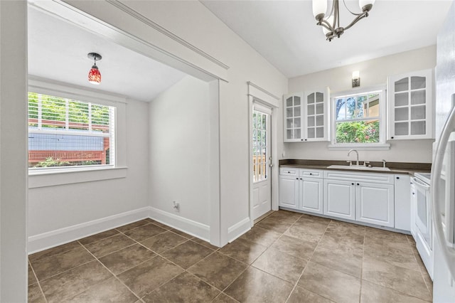 906 E Broad St, Tampa, FL 33604 - kitchen featuring dark countertops, a chandelier, white cabinetry, and glass insert cabinets
