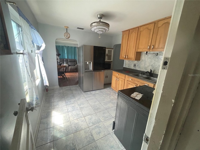 2435 37th Ave N, Saint Petersburg, FL 33713 - kitchen featuring stainless steel refrigerator with ice dispenser, a sink, dark countertops, stove, and arched walkways