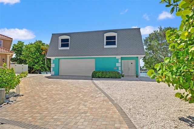 3021 Alton Dr, St Pete Beach, FL 33706 - view of front of house featuring a garage, decorative driveway, stucco siding, and mansard roof