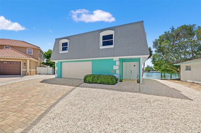 3021 Alton Dr, St Pete Beach, FL 33706 - view of front of property featuring decorative driveway, a garage, and stucco siding