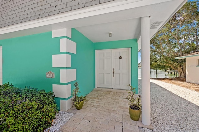 3021 Alton Dr, St Pete Beach, FL 33706 - doorway to property with a shingled roof and stucco siding