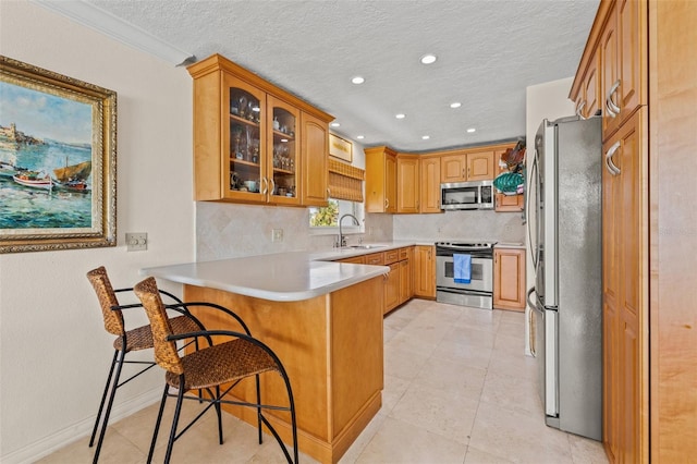 3021 Alton Dr, St Pete Beach, FL 33706 - kitchen with appliances with stainless steel finishes, a peninsula, a breakfast bar area, glass insert cabinets, and a sink