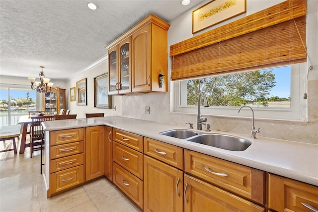 3021 Alton Dr, St Pete Beach, FL 33706 - kitchen featuring a sink, plenty of natural light, light countertops, tasteful backsplash, and a textured ceiling