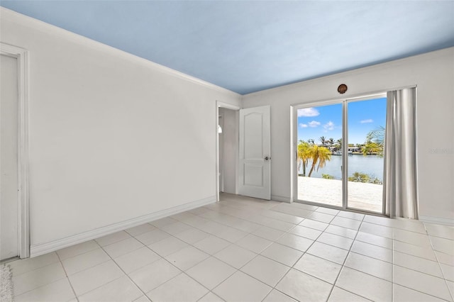 3021 Alton Dr, St Pete Beach, FL 33706 - spare room featuring a water view, crown molding, baseboards, and light tile patterned flooring