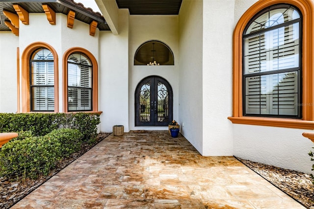 property entrance featuring french doors and stucco siding