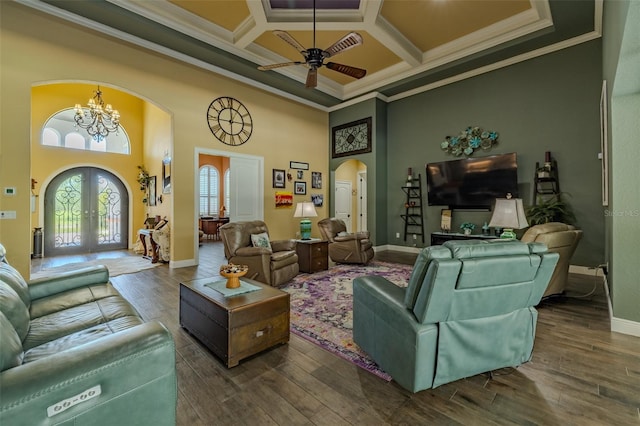 living area with crown molding, arched walkways, french doors, ceiling fan with notable chandelier, and a towering ceiling