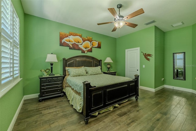 bedroom with dark wood-style flooring, baseboards, visible vents, and multiple windows