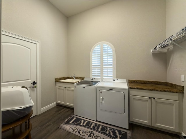 laundry room with cabinet space, a sink, baseboards, dark wood-type flooring, and washer and clothes dryer