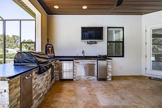 view of patio / terrace with an outdoor kitchen, a sink, a ceiling fan, and a grill