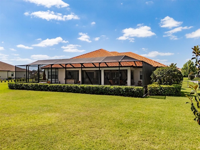 back of house featuring a yard, a tiled roof, and glass enclosure