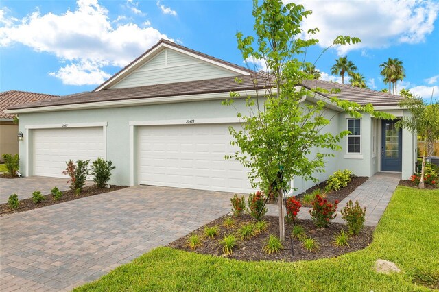 20423 Symphony Pl, Venice, FL 34293 - ranch-style house with decorative driveway, stucco siding, and a garage