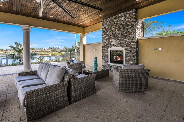 20423 Symphony Pl, Venice, FL 34293 - view of patio featuring an outdoor living space with a fireplace, fence, and a water view
