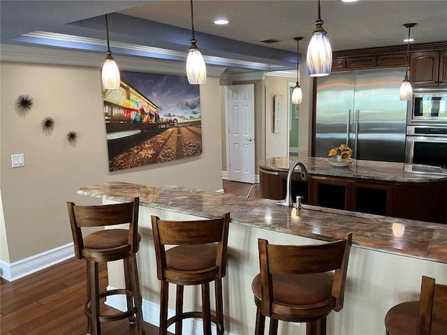 324 6th Ave, Indian Rocks Beach, FL 33785 - kitchen featuring visible vents, baseboards, dark wood-style floors, stone counters, and built in appliances