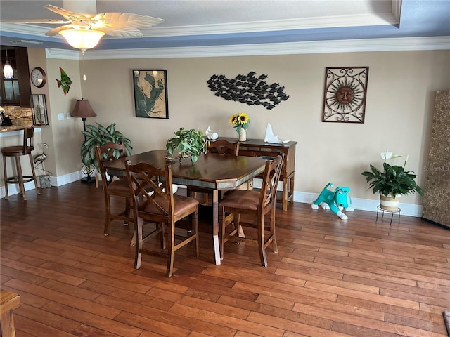 324 6th Ave, Indian Rocks Beach, FL 33785 - dining area with ornamental molding, a tray ceiling, and hardwood / wood-style flooring