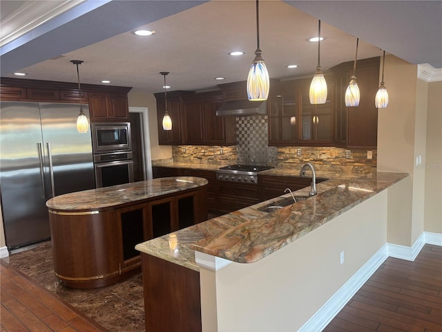 324 6th Ave, Indian Rocks Beach, FL 33785 - kitchen with dark brown cabinets, a sink, built in appliances, baseboards, and decorative backsplash