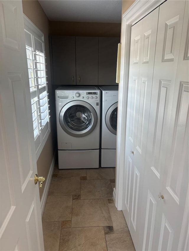 324 6th Ave, Indian Rocks Beach, FL 33785 - washroom featuring baseboards, stone finish flooring, cabinet space, and washer and dryer