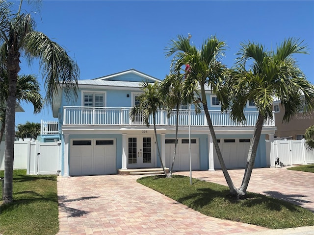 324 6th Ave, Indian Rocks Beach, FL 33785 - coastal home featuring decorative driveway, french doors, a gate, and a garage