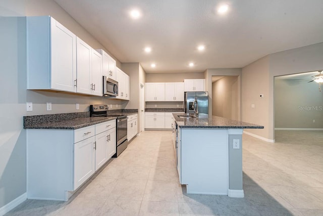 kitchen with white cabinets, a kitchen island with sink, stainless steel appliances, and recessed lighting