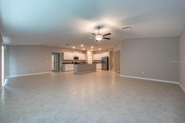 unfurnished living room with a ceiling fan, visible vents, a sink, baseboards, and recessed lighting