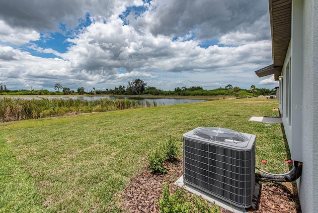 view of yard with a water view and central AC