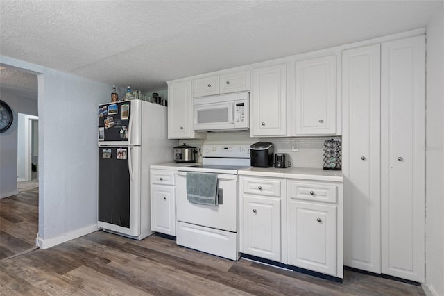 kitchen with white appliances, a textured ceiling, and white cabinetry