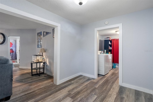 hall featuring baseboards, a textured ceiling, and wood finished floors