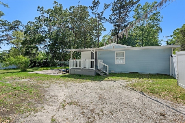 exterior space with fence, a wooden deck, and a yard