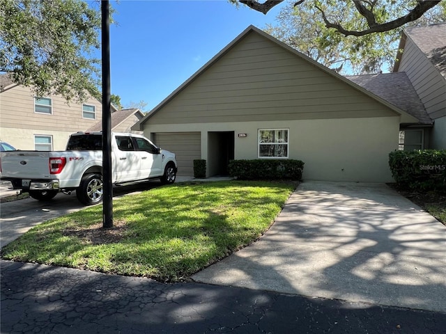 2826 Rampart Cir, Clearwater, FL 33761 - view of front facade with a front lawn, driveway, stucco siding, and a garage