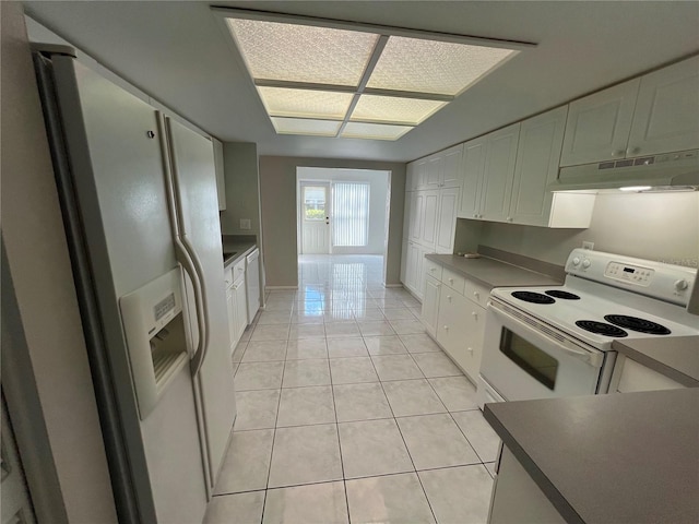 2826 Rampart Cir, Clearwater, FL 33761 - kitchen featuring white appliances, under cabinet range hood, white cabinetry, light tile patterned floors, and dark countertops