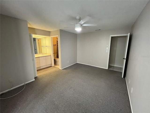 2826 Rampart Cir, Clearwater, FL 33761 - unfurnished bedroom with ensuite bath, baseboards, and dark carpet