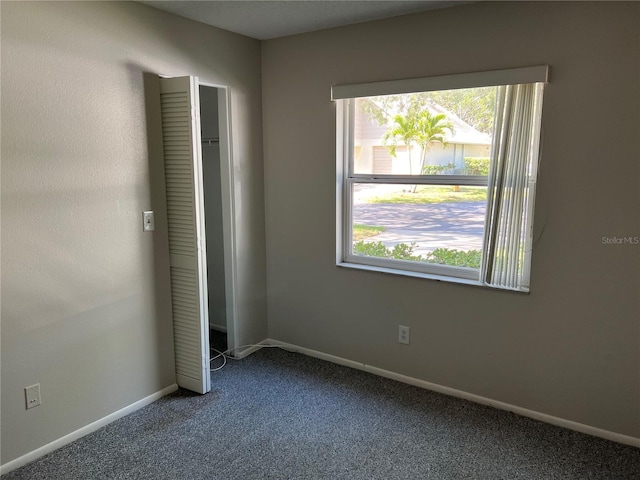2826 Rampart Cir, Clearwater, FL 33761 - unfurnished bedroom featuring dark colored carpet, baseboards, and multiple windows