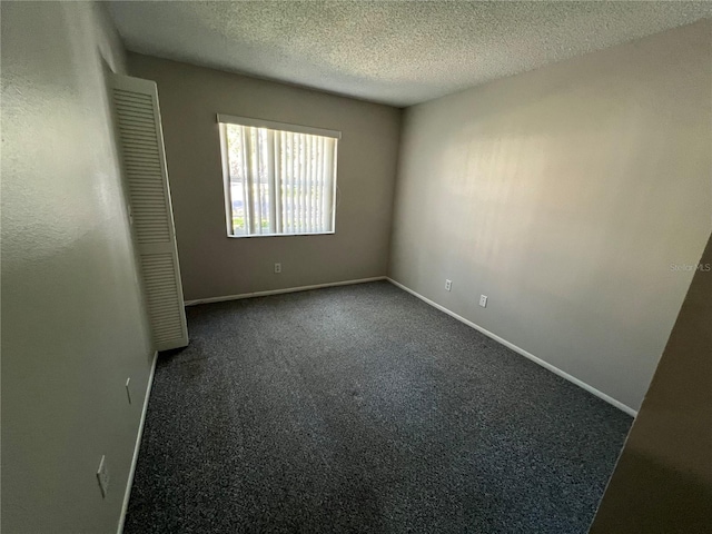 2826 Rampart Cir, Clearwater, FL 33761 - spare room featuring dark colored carpet, a textured ceiling, and baseboards