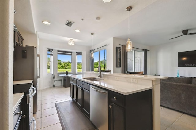 1003 Fairwaycove Ln Unit 103, Bradenton, FL 34212 - kitchen featuring appliances with stainless steel finishes, a sink, open floor plan, light tile patterned floors, and light countertops