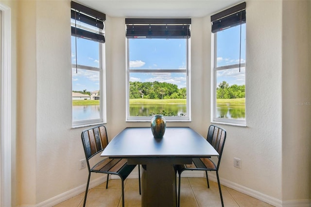 1003 Fairwaycove Ln Unit 103, Bradenton, FL 34212 - dining room featuring plenty of natural light, baseboards, a water view, and a textured wall