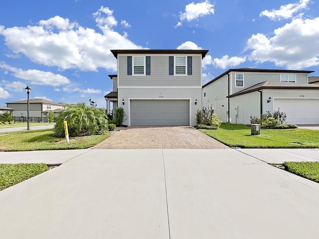 17737 Everlong Dr, Land O Lakes, FL 34638 - view of front of house with a garage, stucco siding, decorative driveway, and a front yard