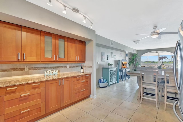 kitchen with visible vents, ceiling fan, light tile patterned floors, and brown cabinets