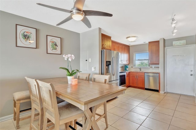 dining area with light tile patterned floors, a ceiling fan, and rail lighting