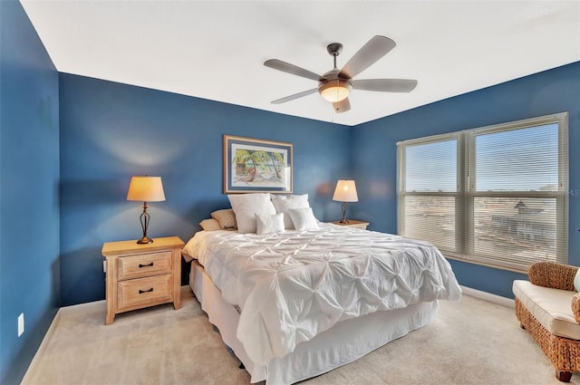 bedroom with baseboards, a ceiling fan, and light carpet