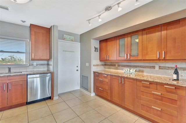 kitchen featuring visible vents, a sink, brown cabinetry, and dishwasher