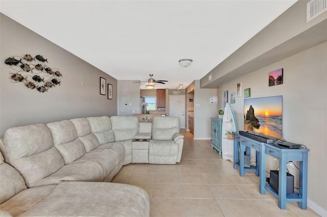 living area featuring visible vents, baseboards, ceiling fan, and light tile patterned flooring