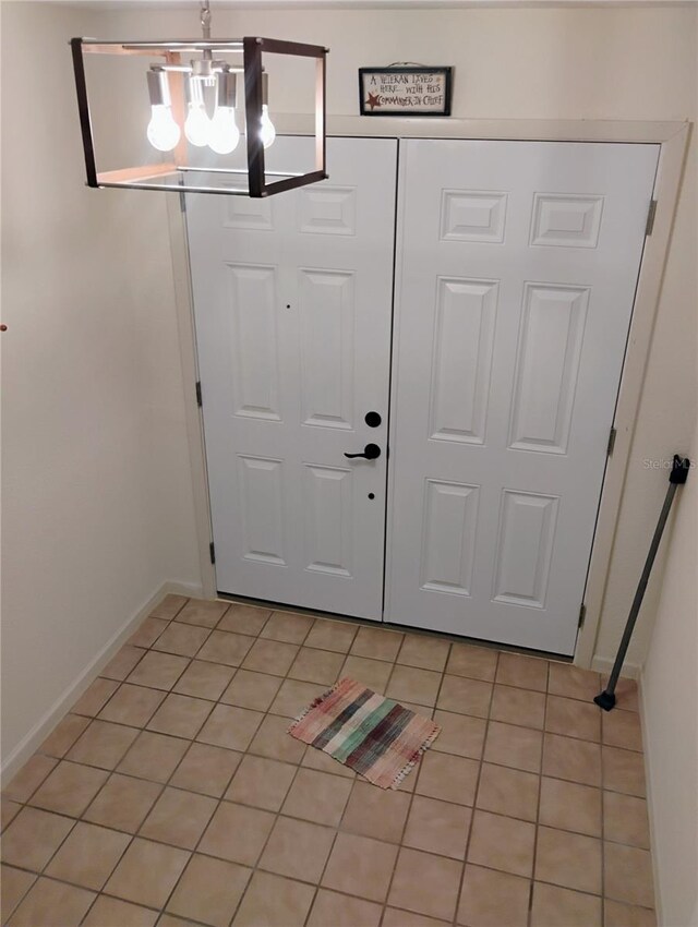7085 Sunset Dr S Unit A, Saint Petersburg, FL 33707 - entryway with a chandelier, light tile patterned floors, and baseboards