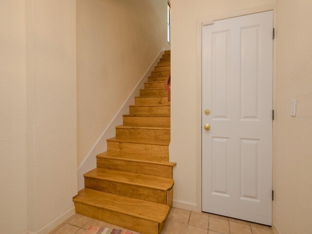 7085 Sunset Dr S Unit A, Saint Petersburg, FL 33707 - staircase with tile patterned flooring and baseboards