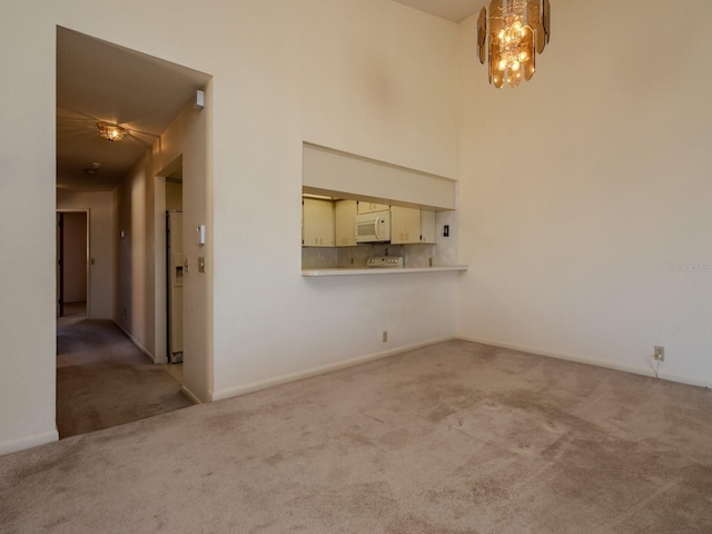 7085 Sunset Dr S Unit A, Saint Petersburg, FL 33707 - unfurnished living room with carpet flooring, a chandelier, and baseboards