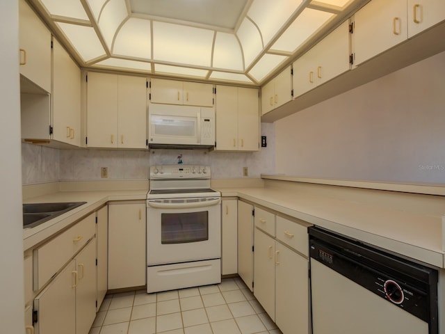 7085 Sunset Dr S Unit A, Saint Petersburg, FL 33707 - kitchen with white appliances, light tile patterned flooring, light countertops, and a sink