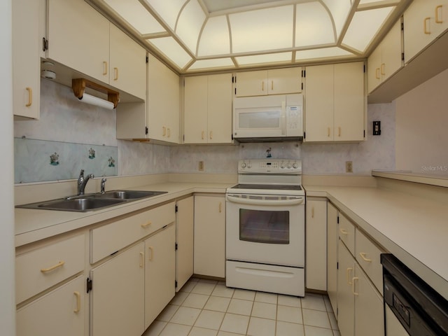 7085 Sunset Dr S Unit A, Saint Petersburg, FL 33707 - kitchen featuring white appliances, a sink, light tile patterned floors, and light countertops