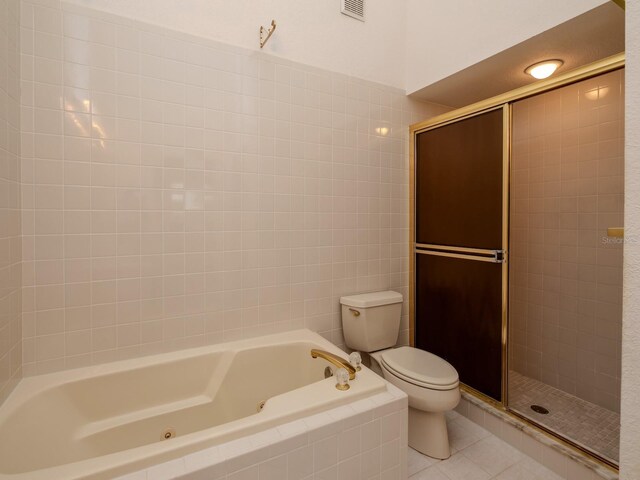 7085 Sunset Dr S Unit A, Saint Petersburg, FL 33707 - full bathroom featuring toilet, a stall shower, a whirlpool tub, and tile patterned floors