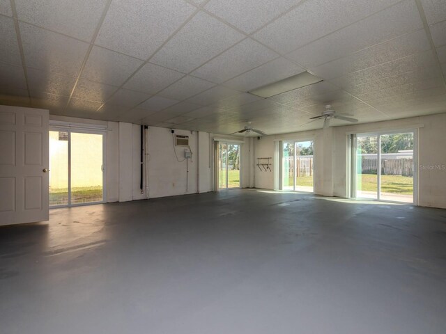 7085 Sunset Dr S Unit A, Saint Petersburg, FL 33707 - empty room with concrete floors, healthy amount of natural light, a drop ceiling, and a wall mounted air conditioner