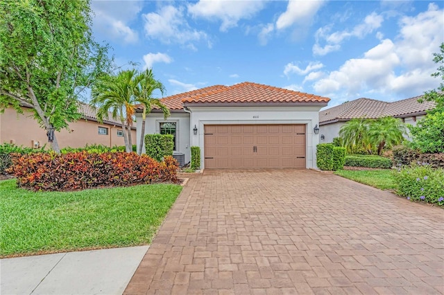 4610 Alexandria Ct, Palmetto, FL 34221 - mediterranean / spanish-style home featuring a tiled roof, decorative driveway, a garage, and stucco siding