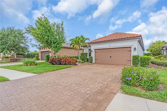 4610 Alexandria Ct, Palmetto, FL 34221 - mediterranean / spanish-style home with a tiled roof, a front yard, a garage, decorative driveway, and stucco siding