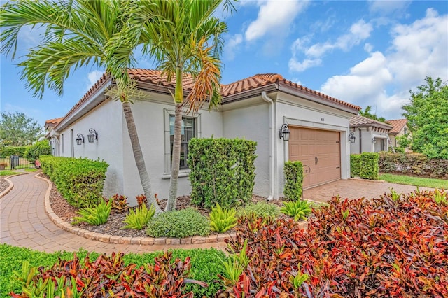 4610 Alexandria Ct, Palmetto, FL 34221 - view of home's exterior with a garage, fence, stucco siding, a tiled roof, and driveway